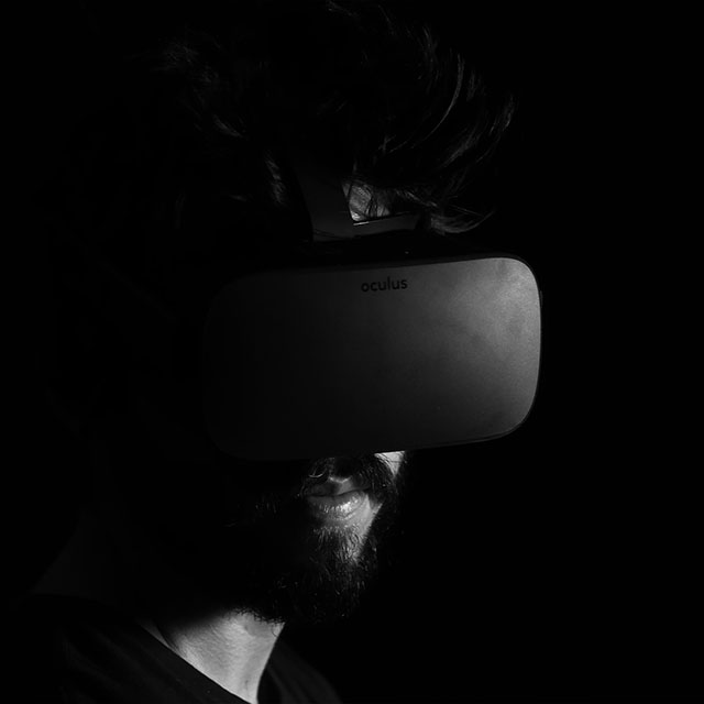 Black and white image of a man wearing a virtual reality headset